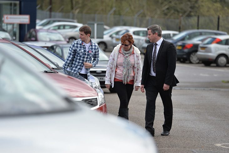 Car dealer and customer on forecourt