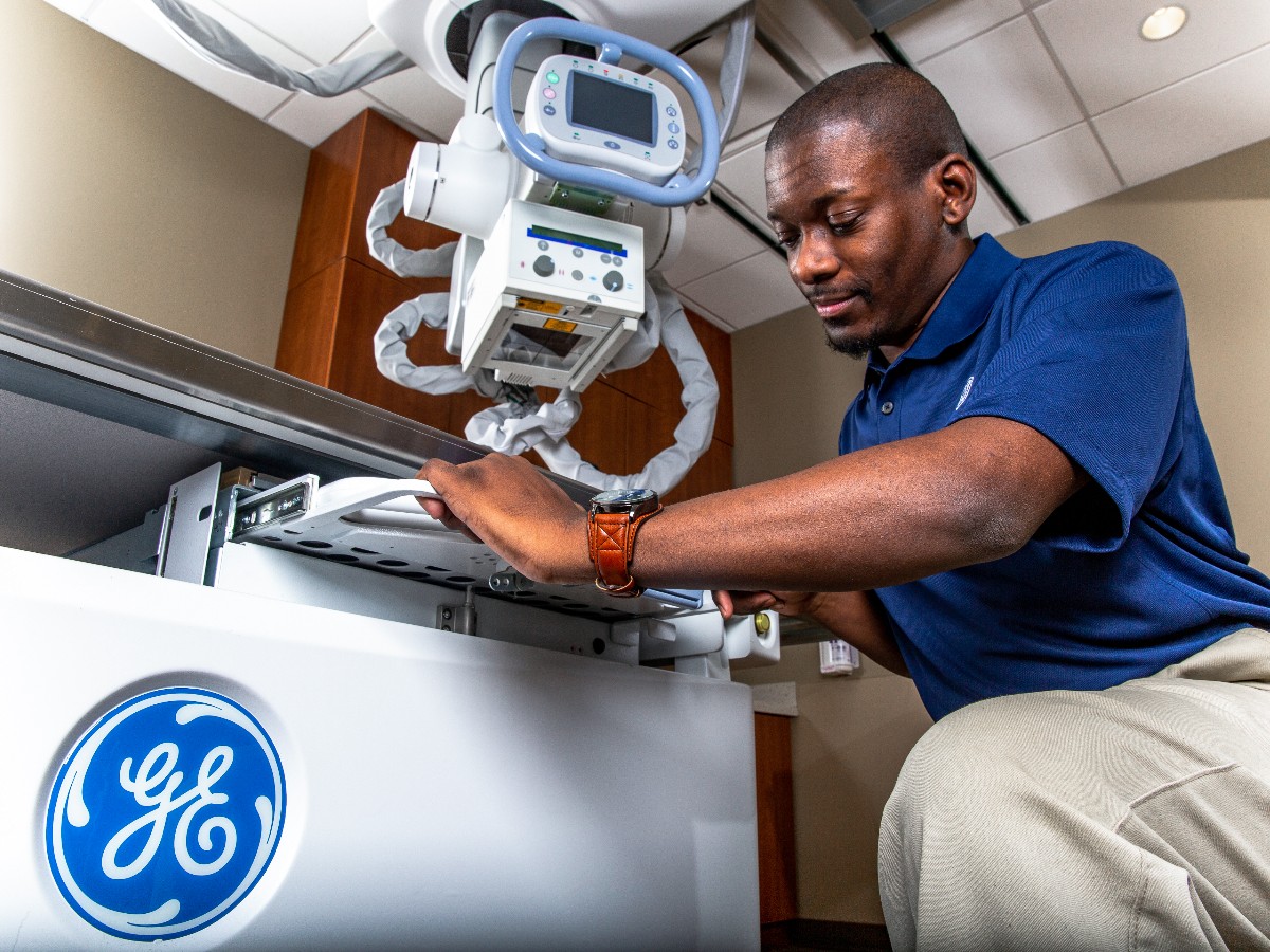GE Healthcare service technician working on a diagnostic imaging machine
