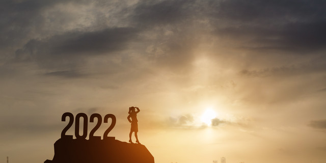 Businesswoman Standing on the mountain with 2022 New Year numbers.