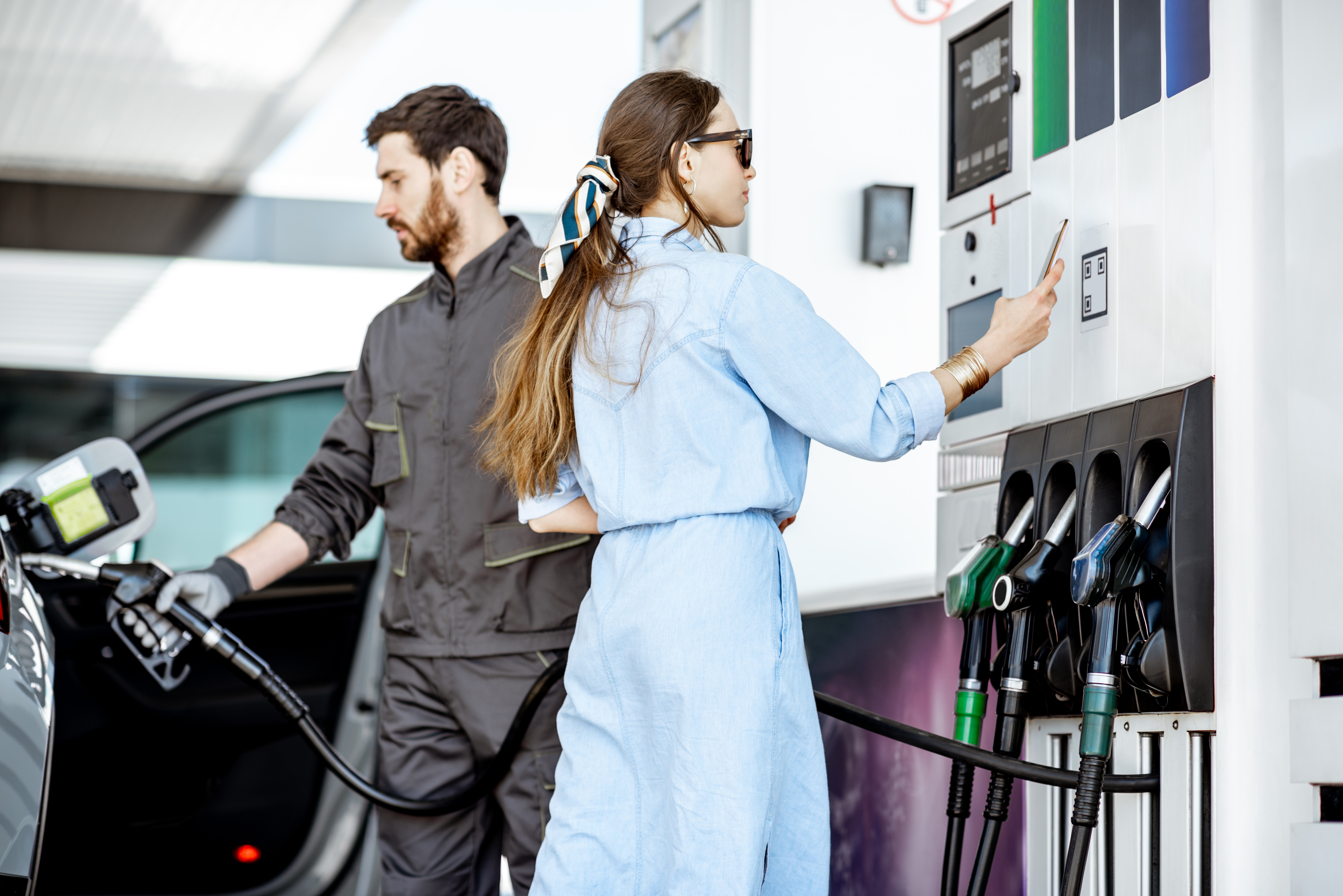 Woman paying with phone at the gas station