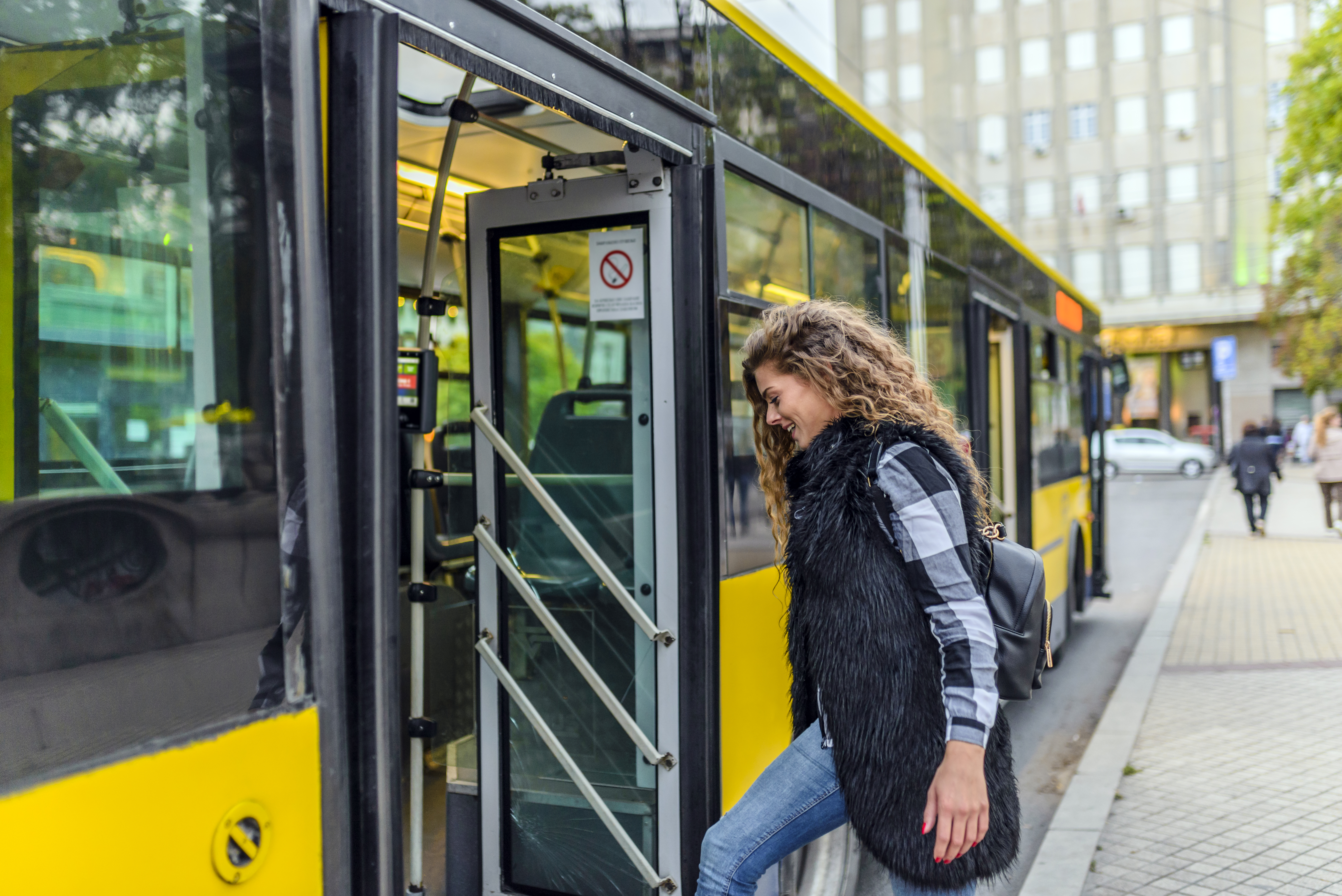 Young woman stepping into the bus