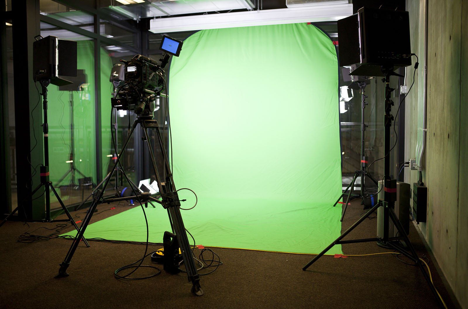 A green screen set up with a camera and lighting set up. 