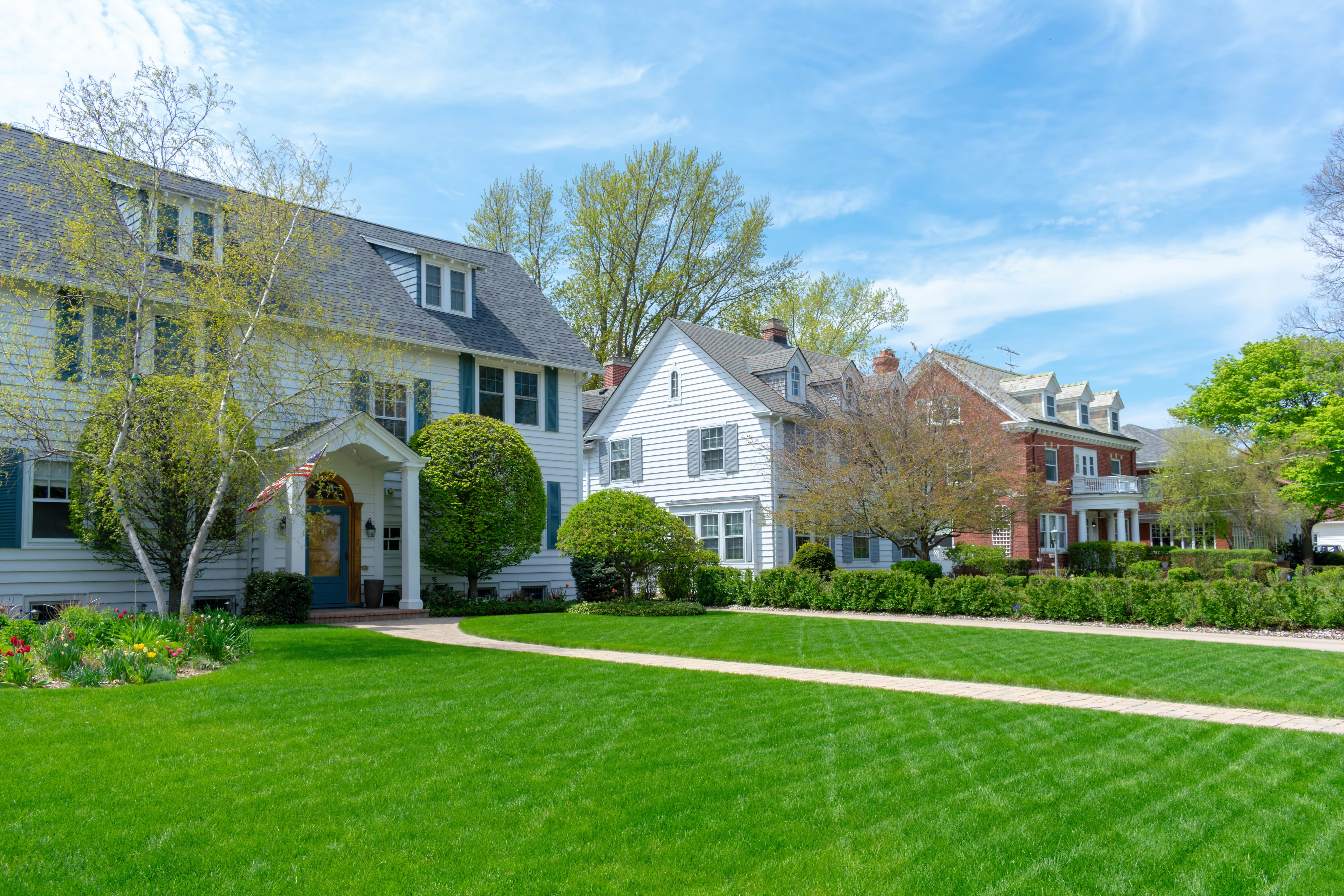 Wide green front lawns in traditional suburban residential neighborhood