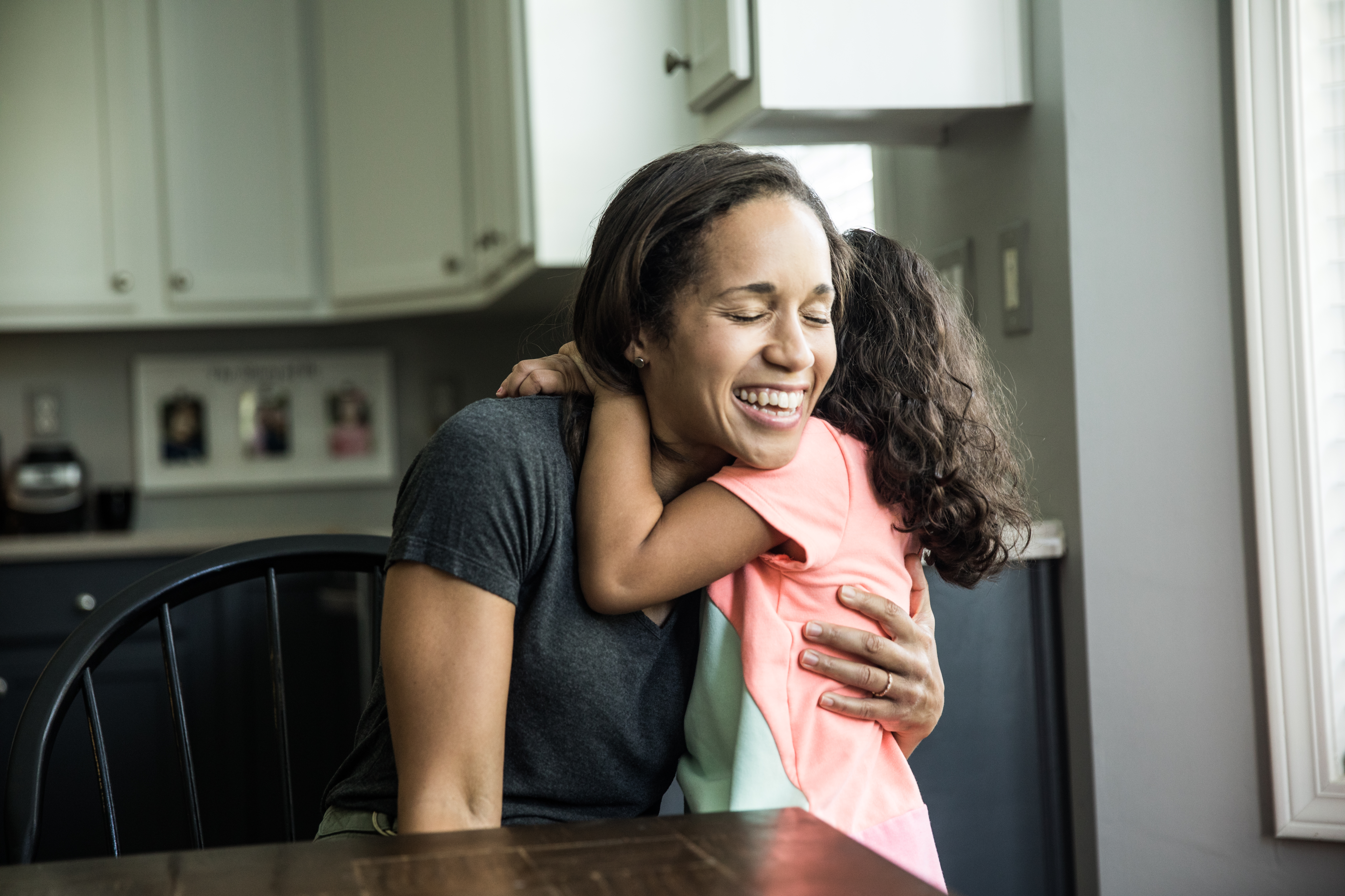 Portrait of mother and daughter at home in kitchen