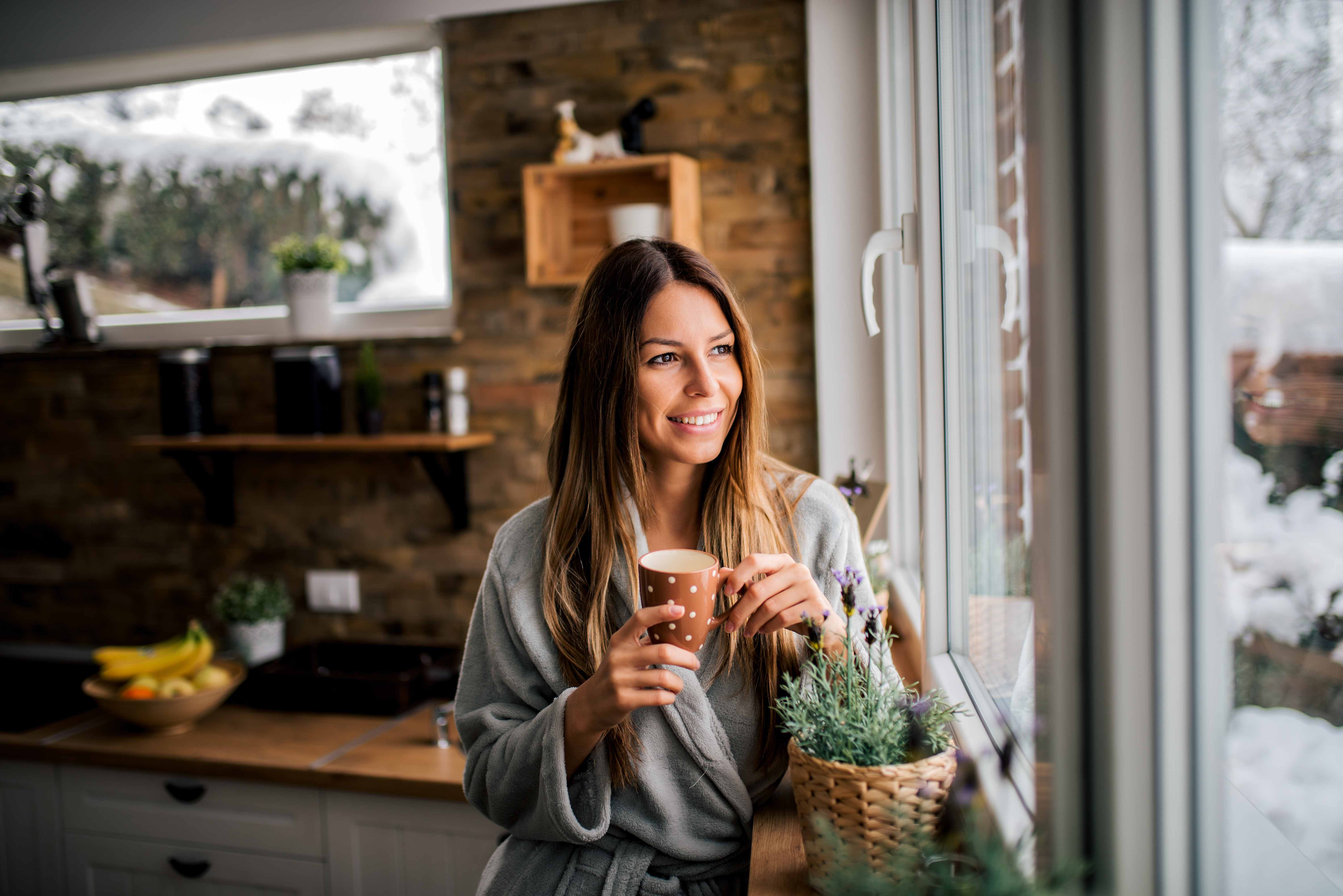 Young woman drinking coffee in the morning, looking at window.