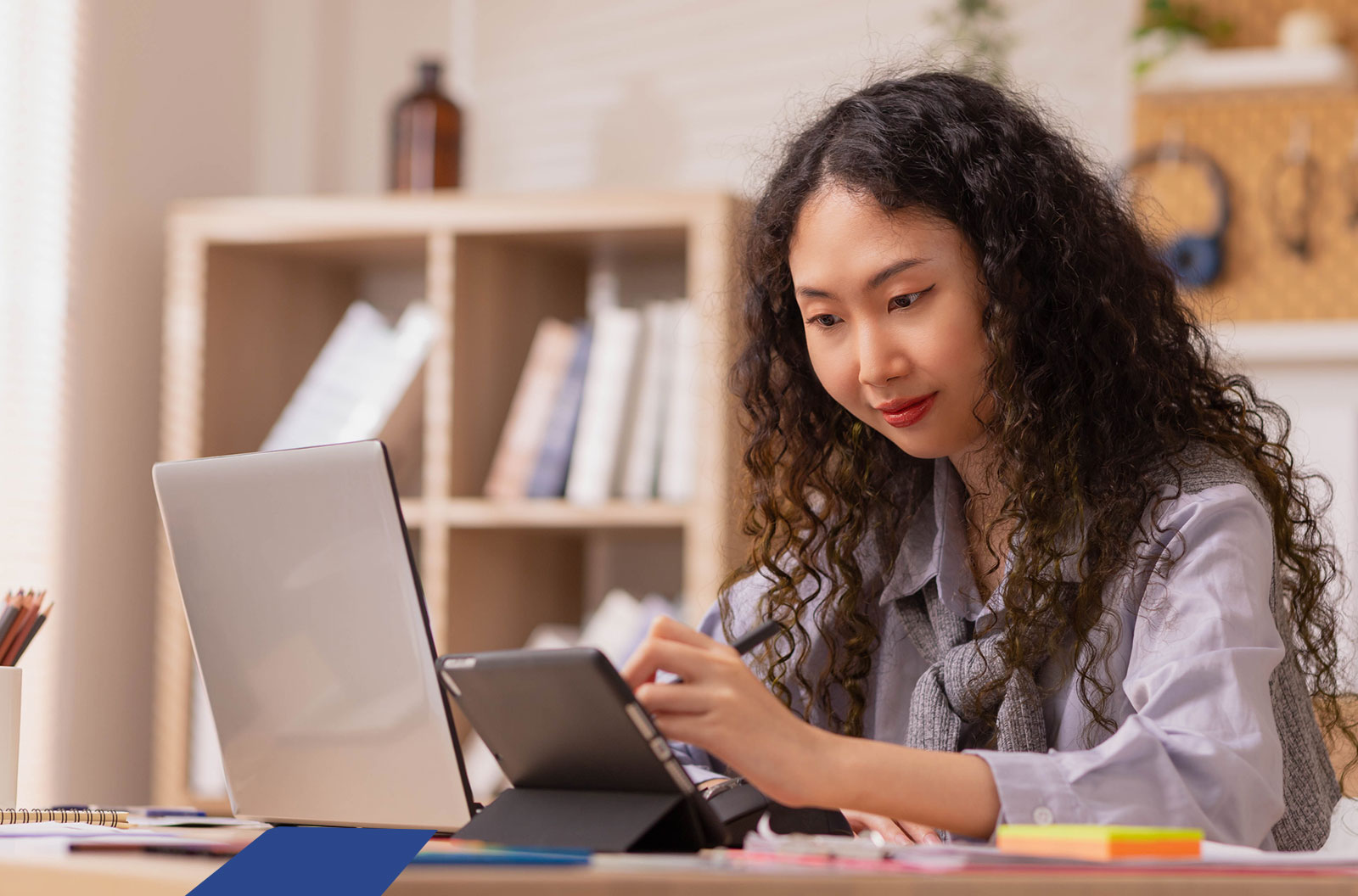 Woman working on a laptop and a tablet. 