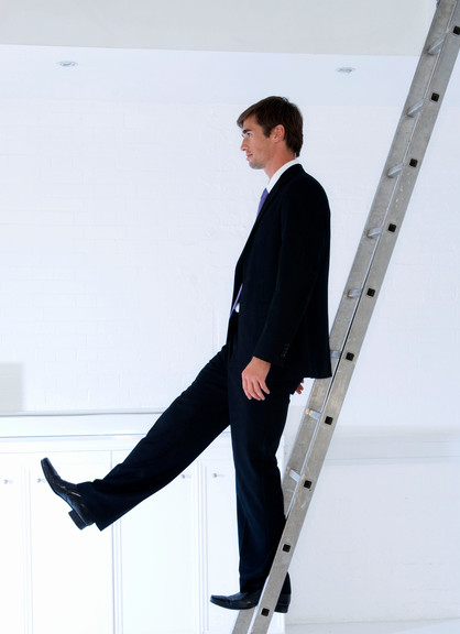 Side profile of a businessman moving down a ladder
