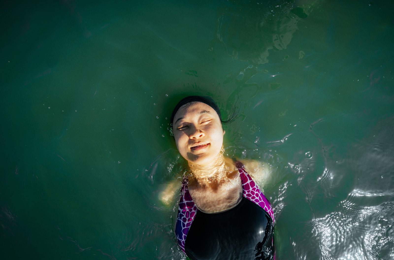 Woman floating through some open water.