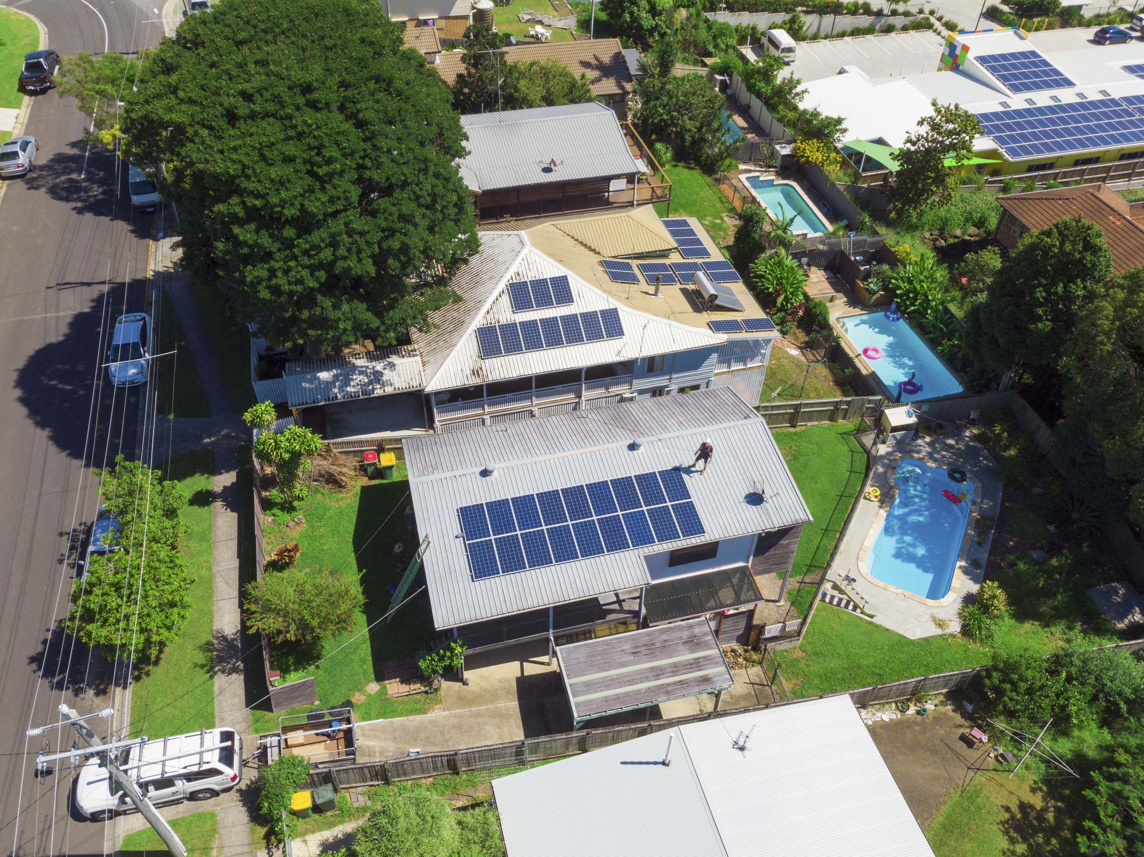 Aerial shot of solar panel technician installing solar panels on roof