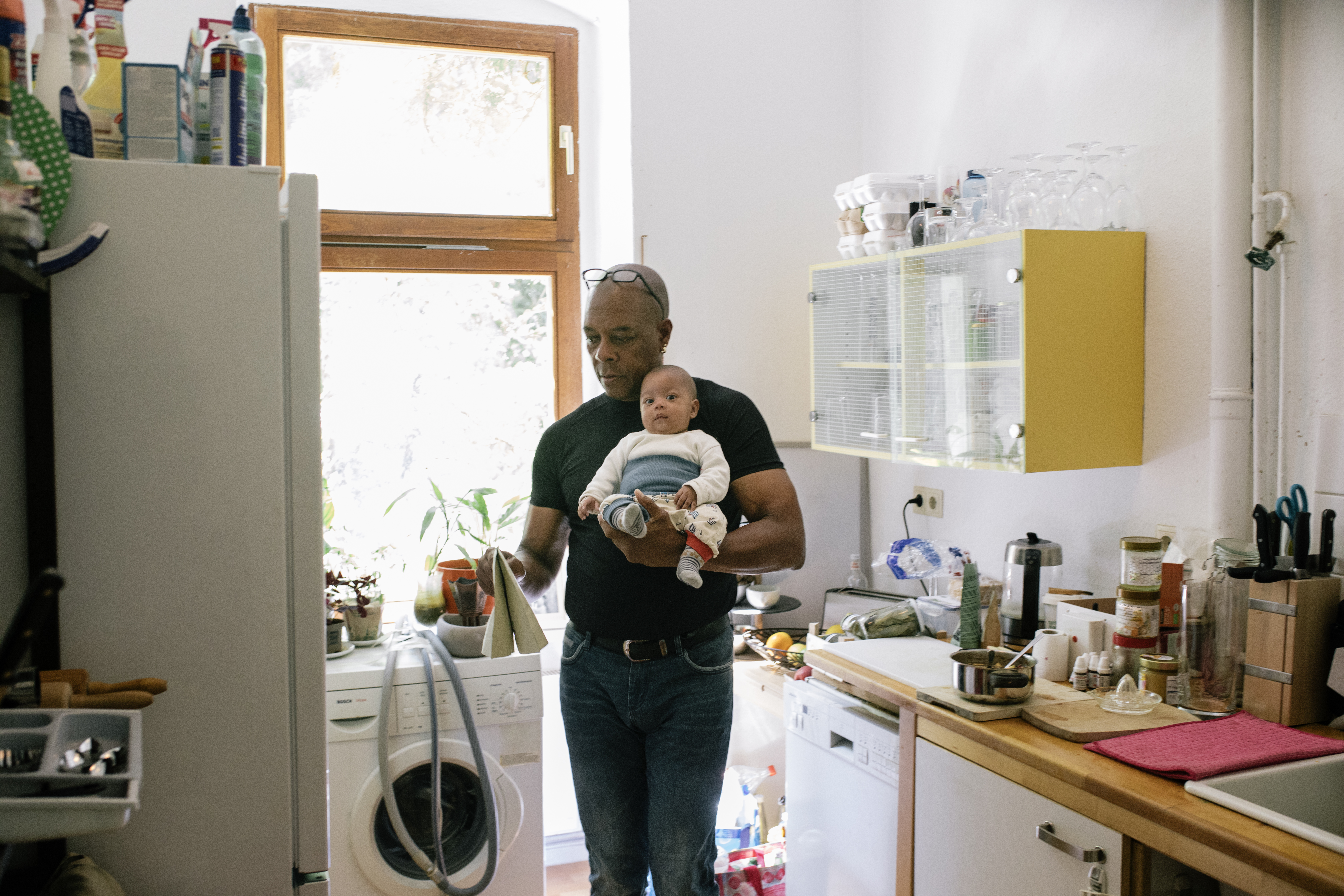 Dad At Home In Kitchen Holding Young Baby