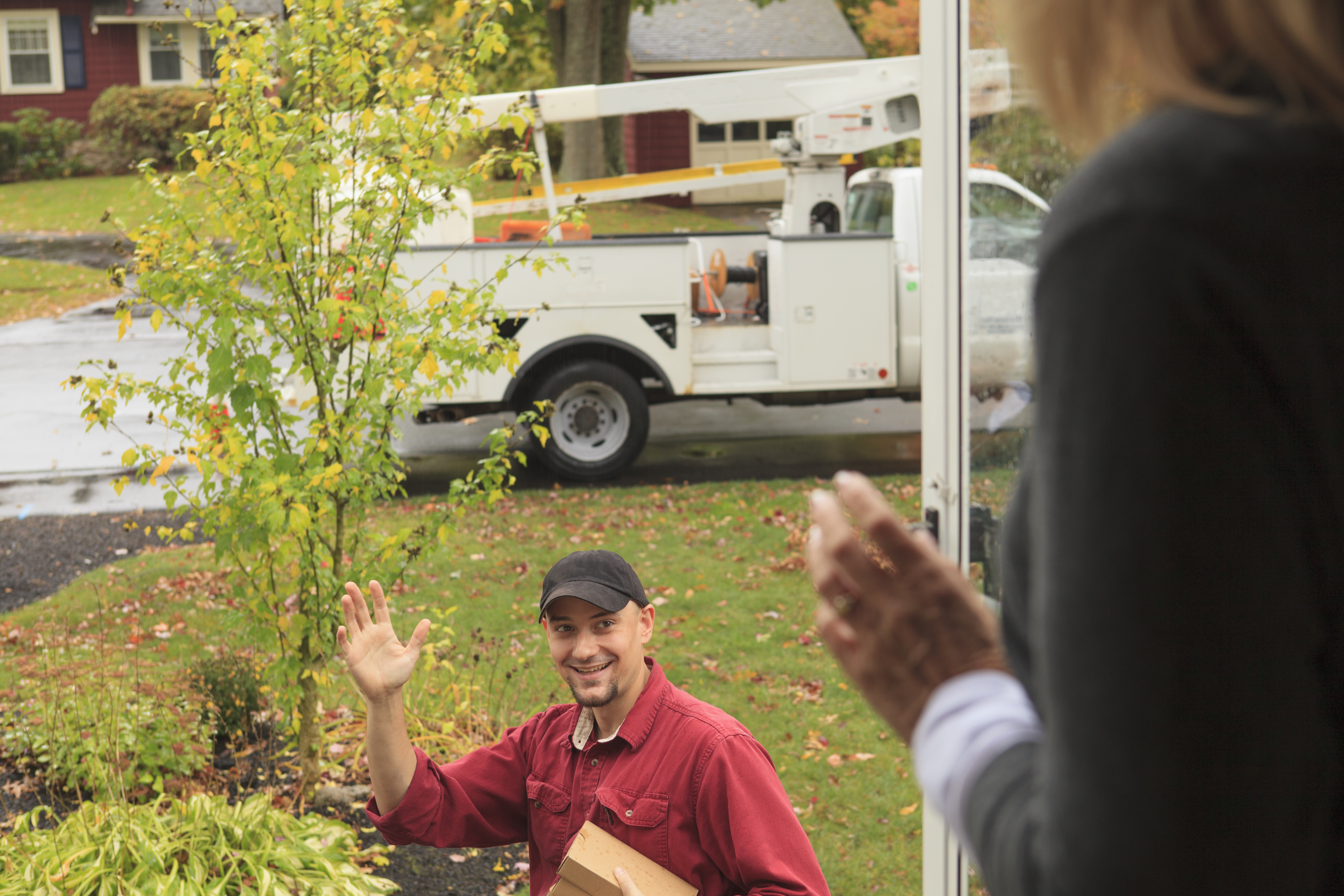 Cable installer leaving and waving to homeowner