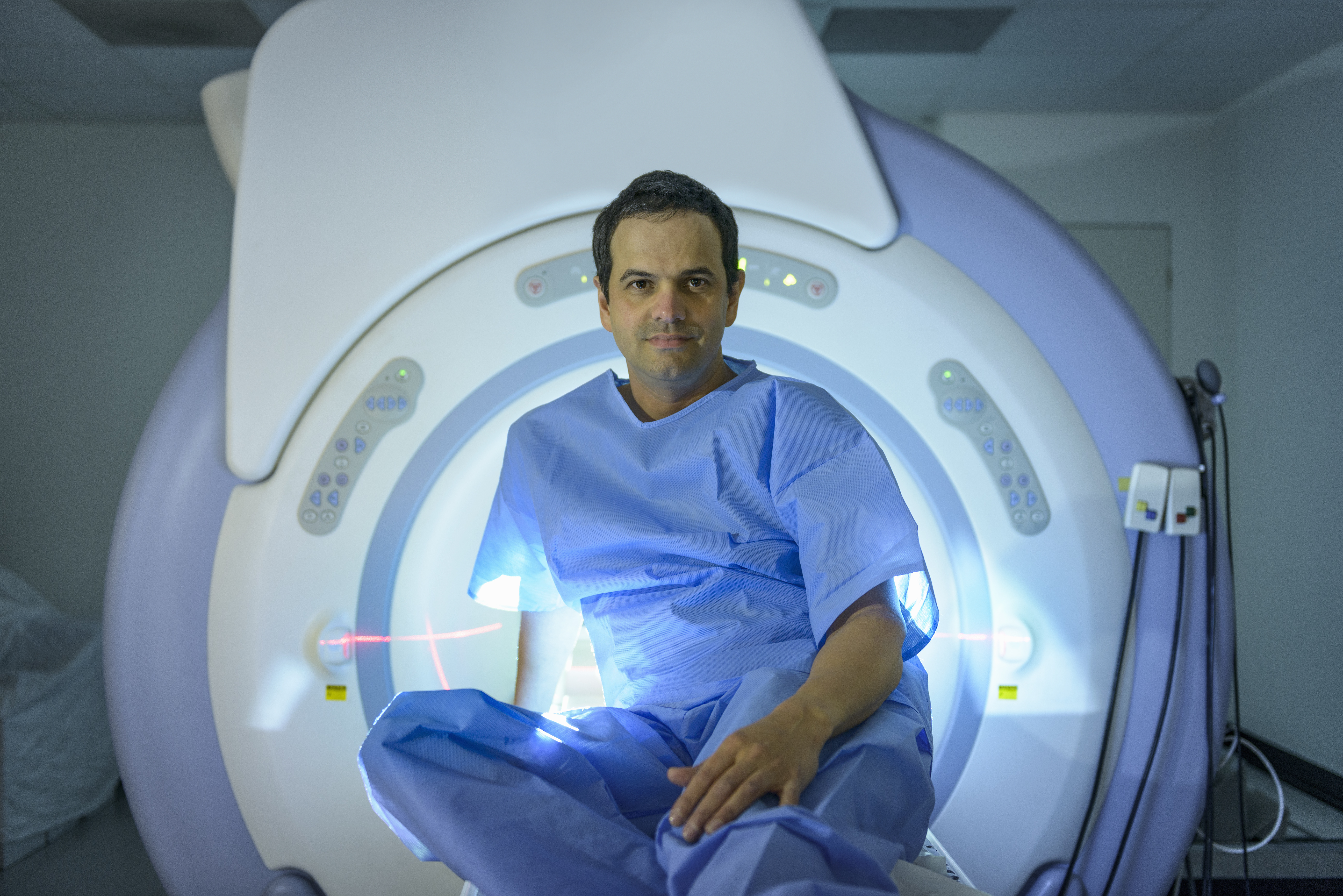 Patient sitting on Magnetic Resonance Imaging (MRI) scanner, portrait