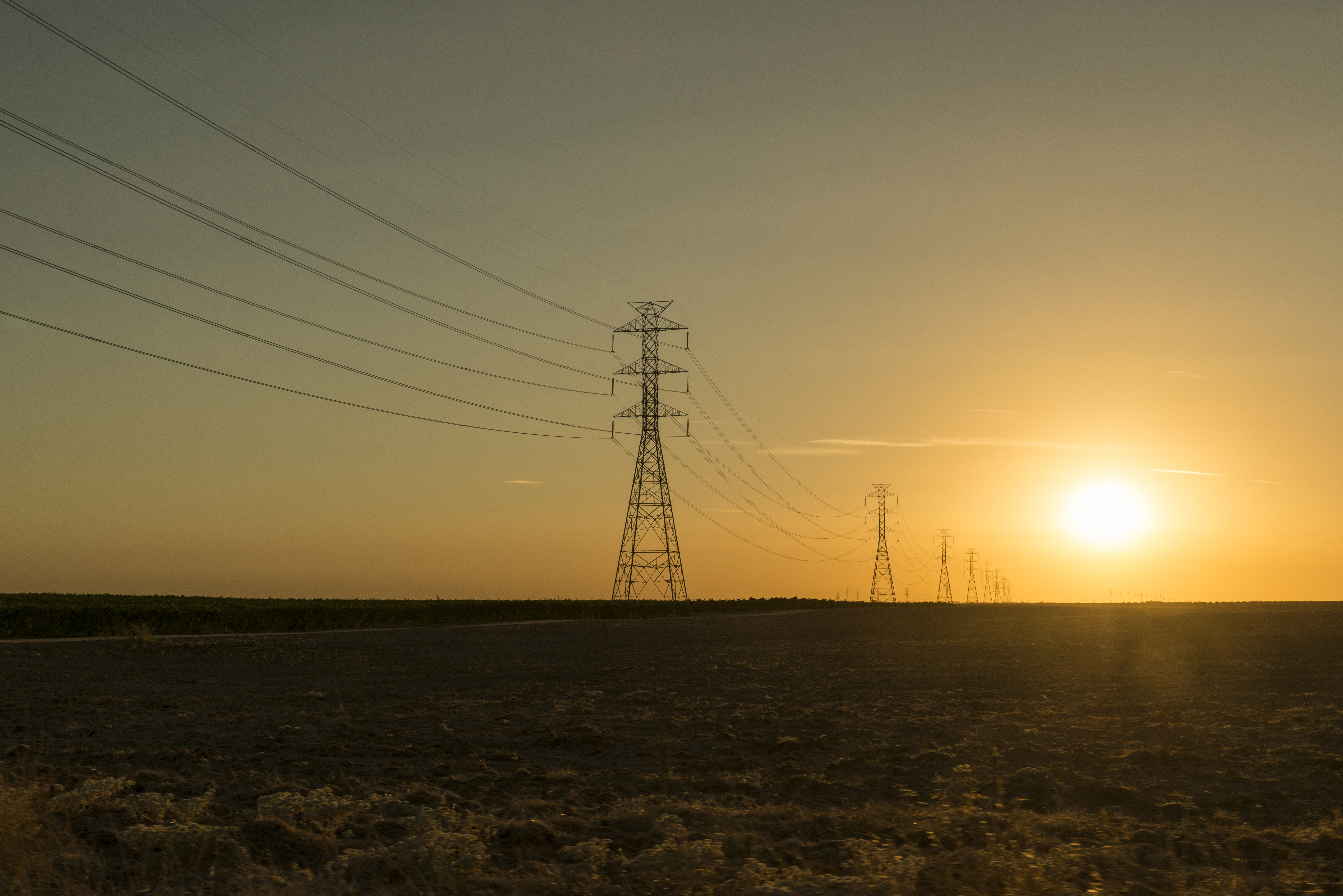 Electrical power transmission lines and pylons on sunset