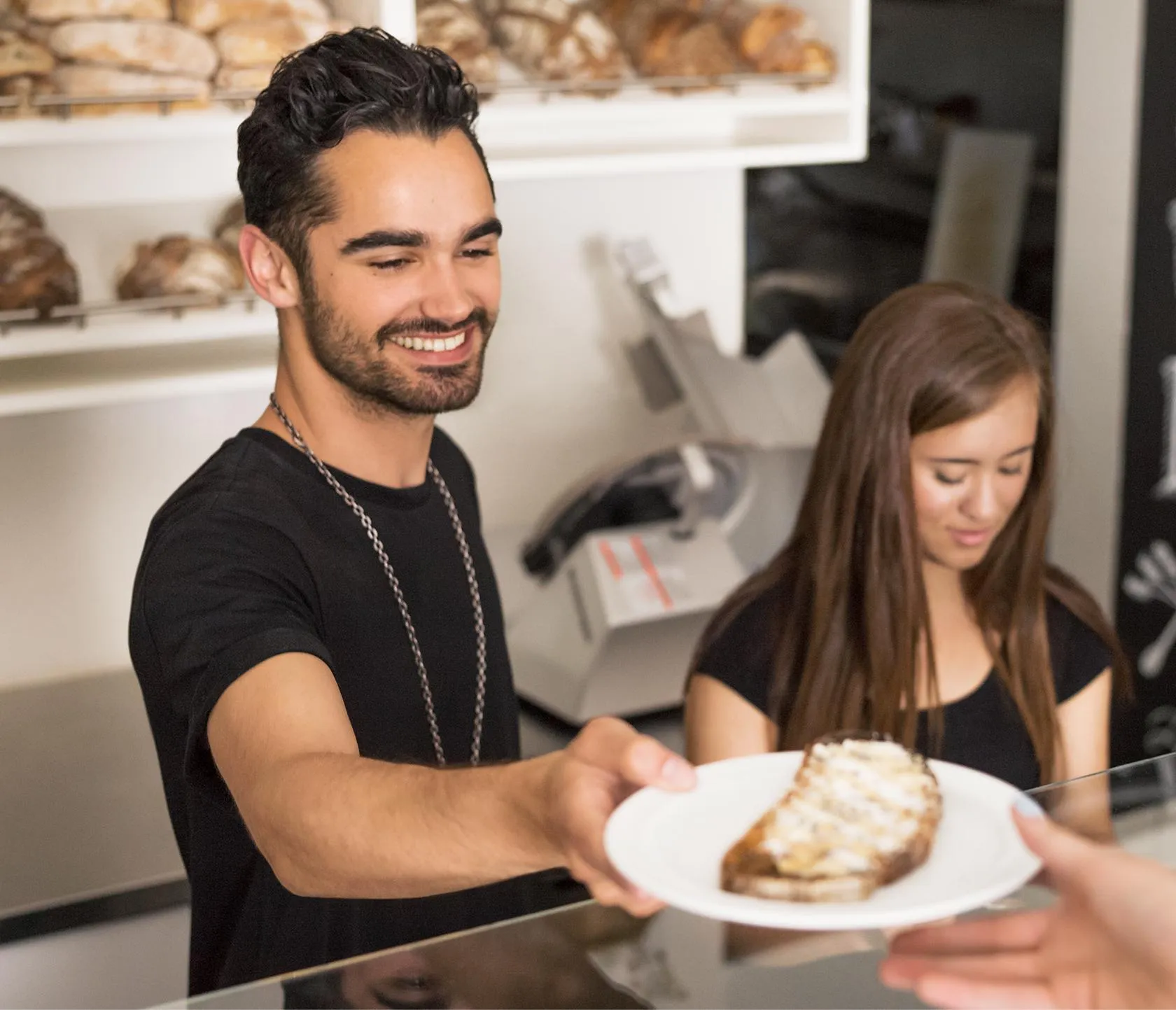 Man handing a customer a plate with toast