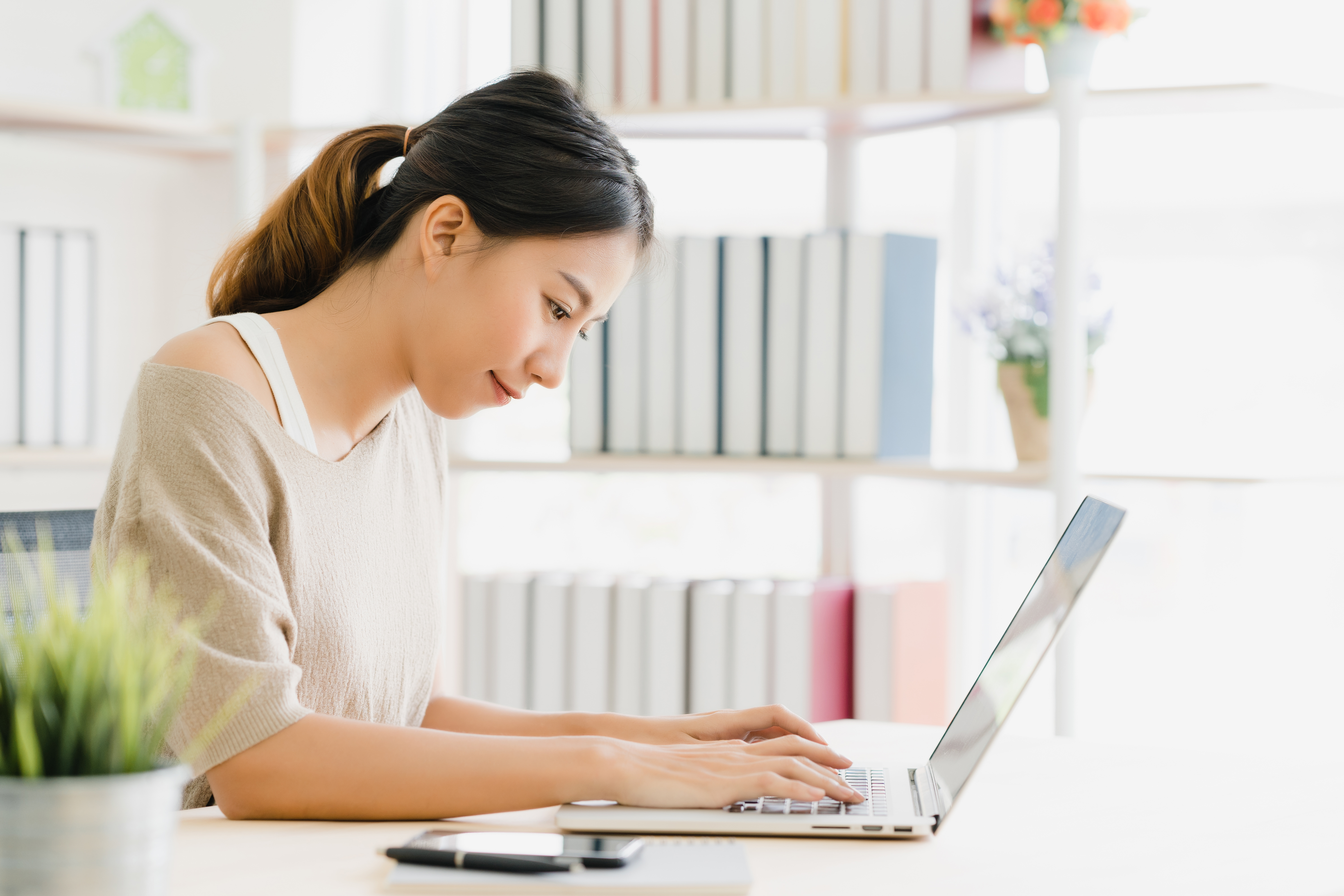 beautiful-young-smiling-asian-woman-working-laptop-desk-living-room-home.jpg