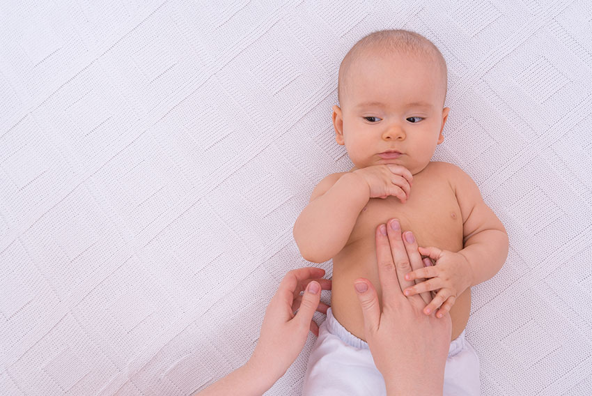 Dojenček uživa v mamičini masaži. Simbolna fotografija za članek Infrantilni spazmi