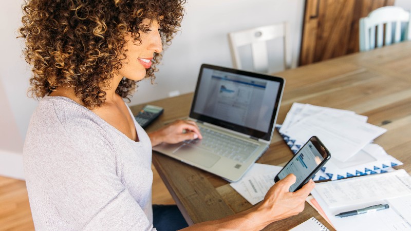 Woman Doing Finances at Home on Smart Phone