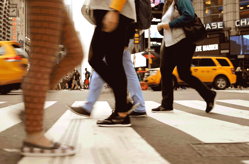 B-roll footage of people crossing a busy crosswalk downtown