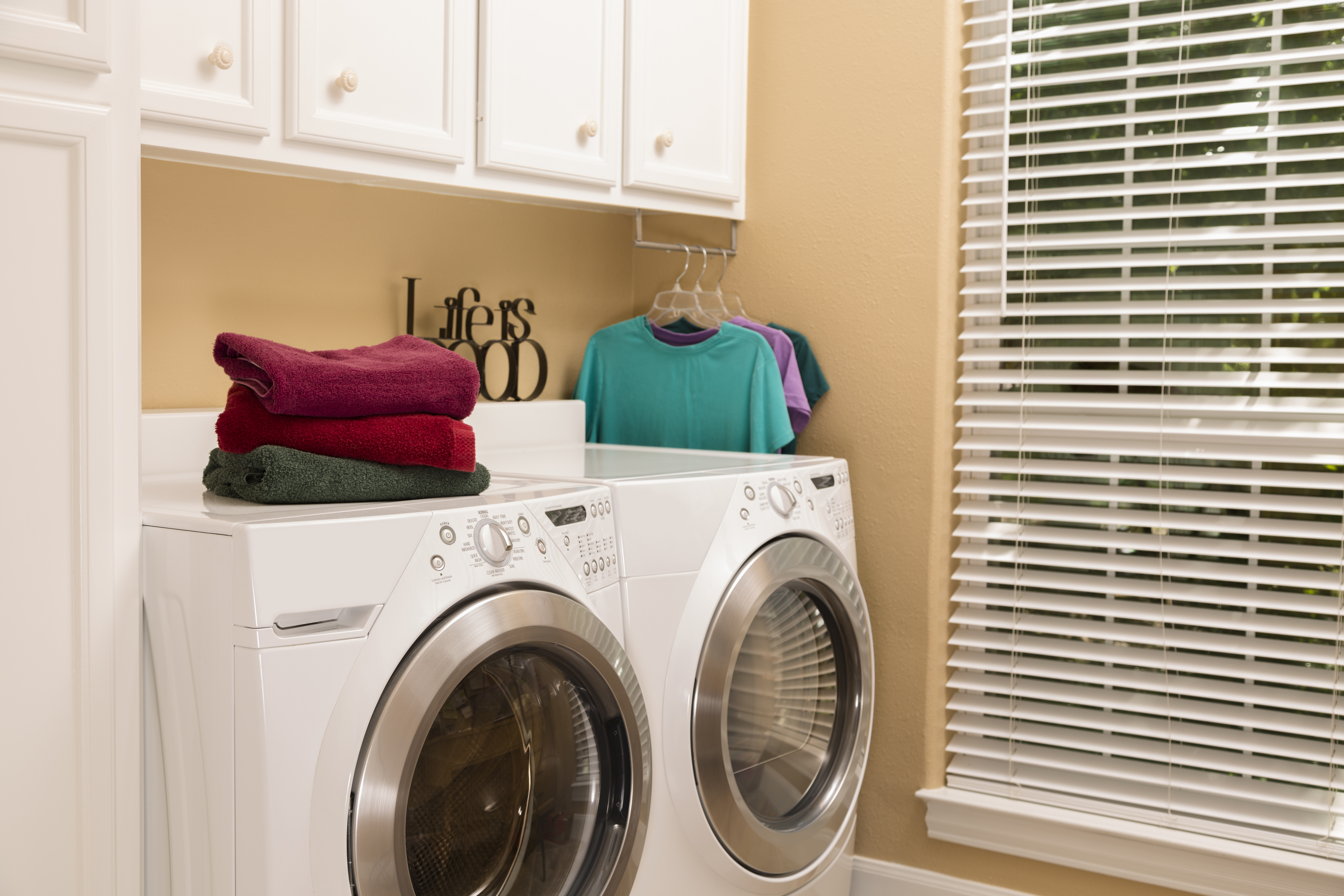 Domestic Life: Laundry room with folded towels, clothes.