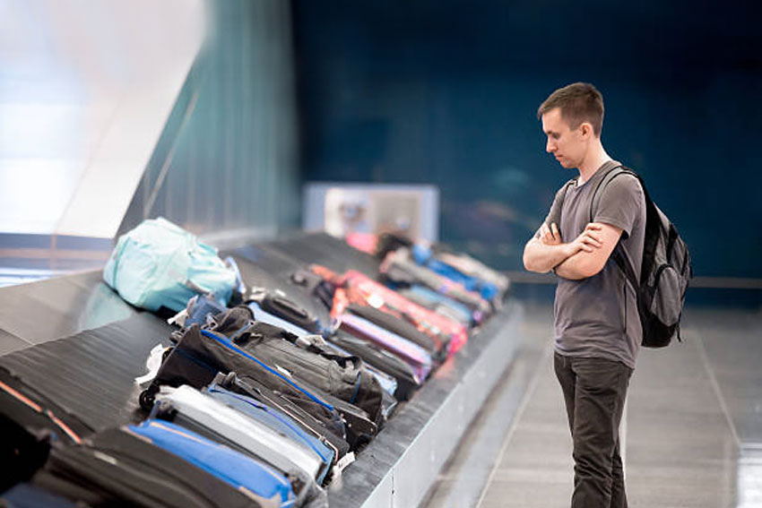 Fant, ki pred tekočim trakom čaka svojo prtljago - izgubljena prtljaga je redni spremljevalec letalskih potovanj