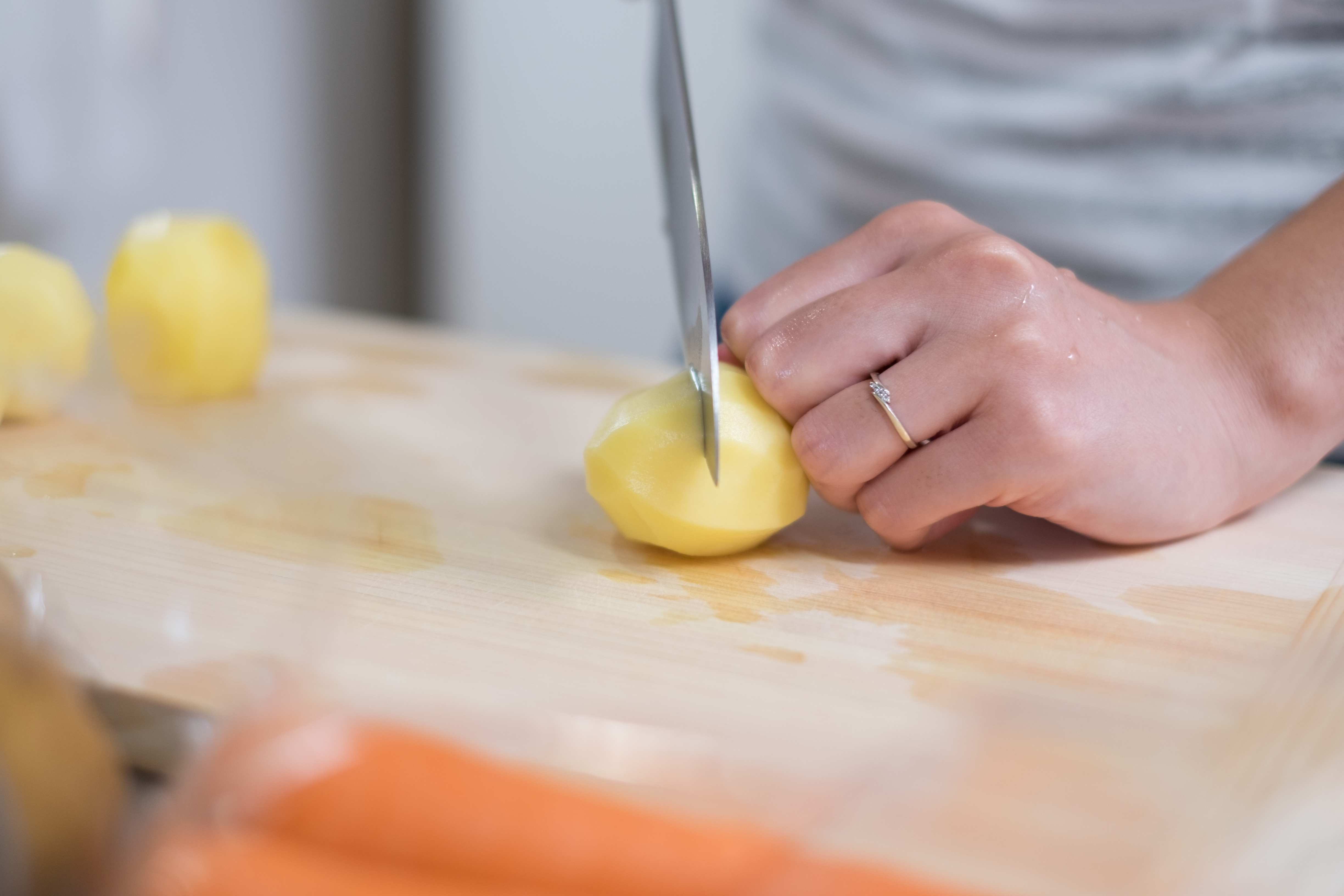 housewife cutting potatoes in kitchen