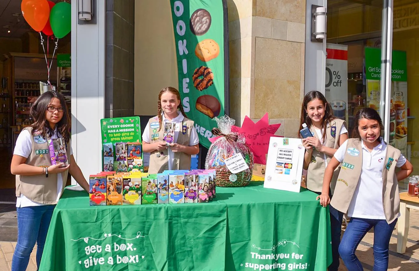 2 girl scouts selling cookies