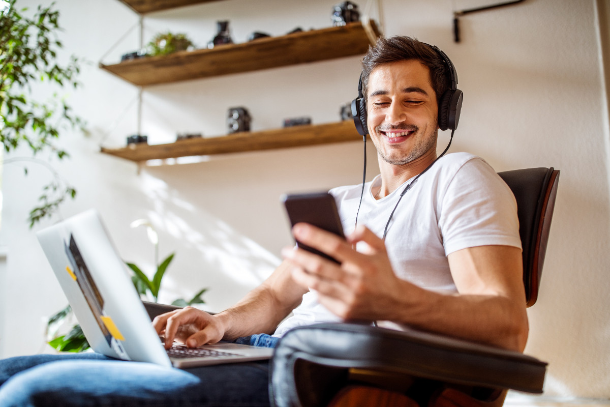 Man listening music while working on laptop