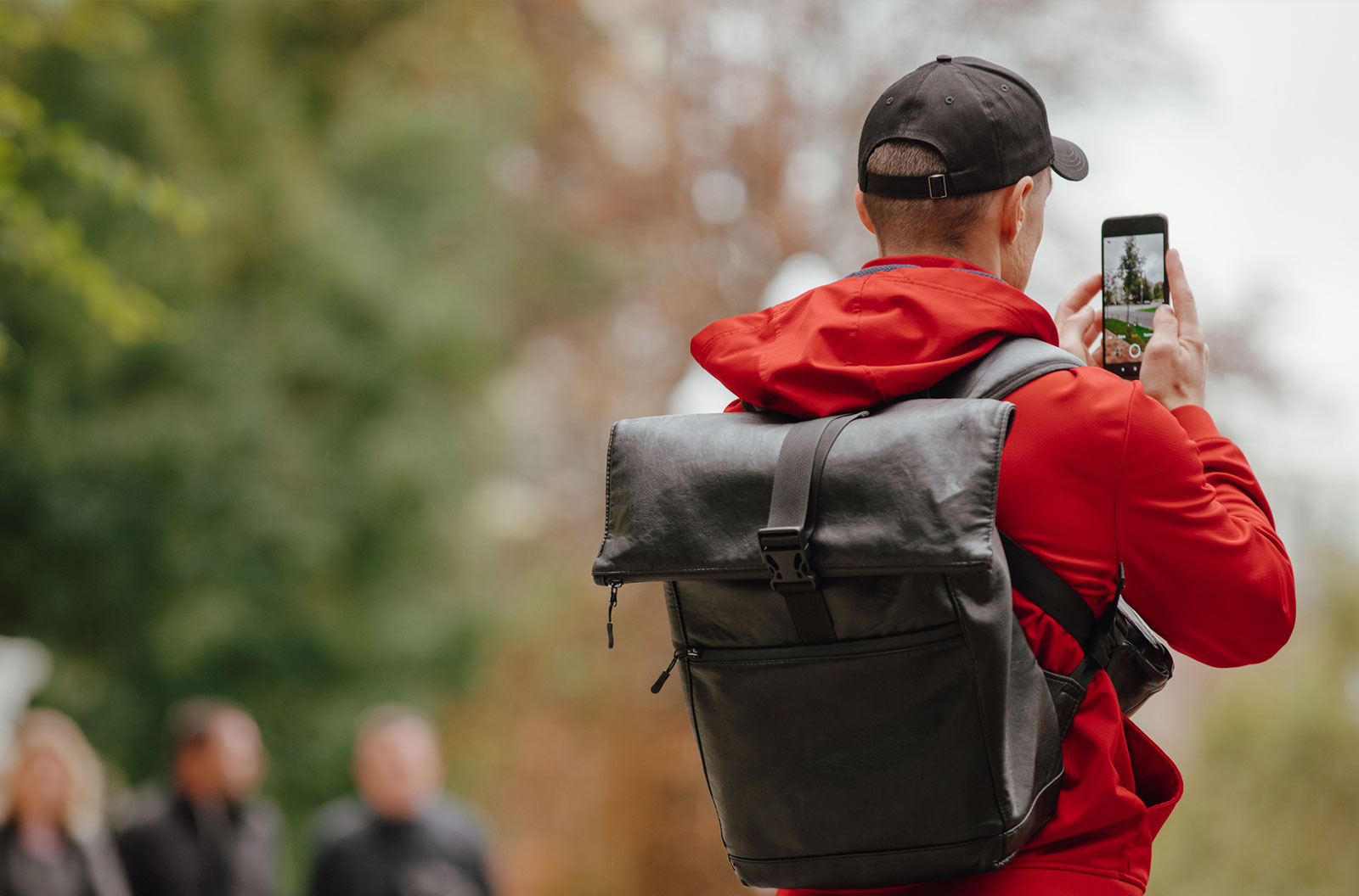 Tourist with backpack photographing city