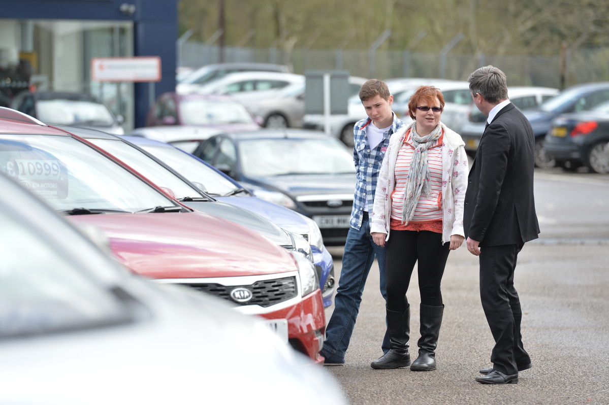 Mother and son talking to car dealer