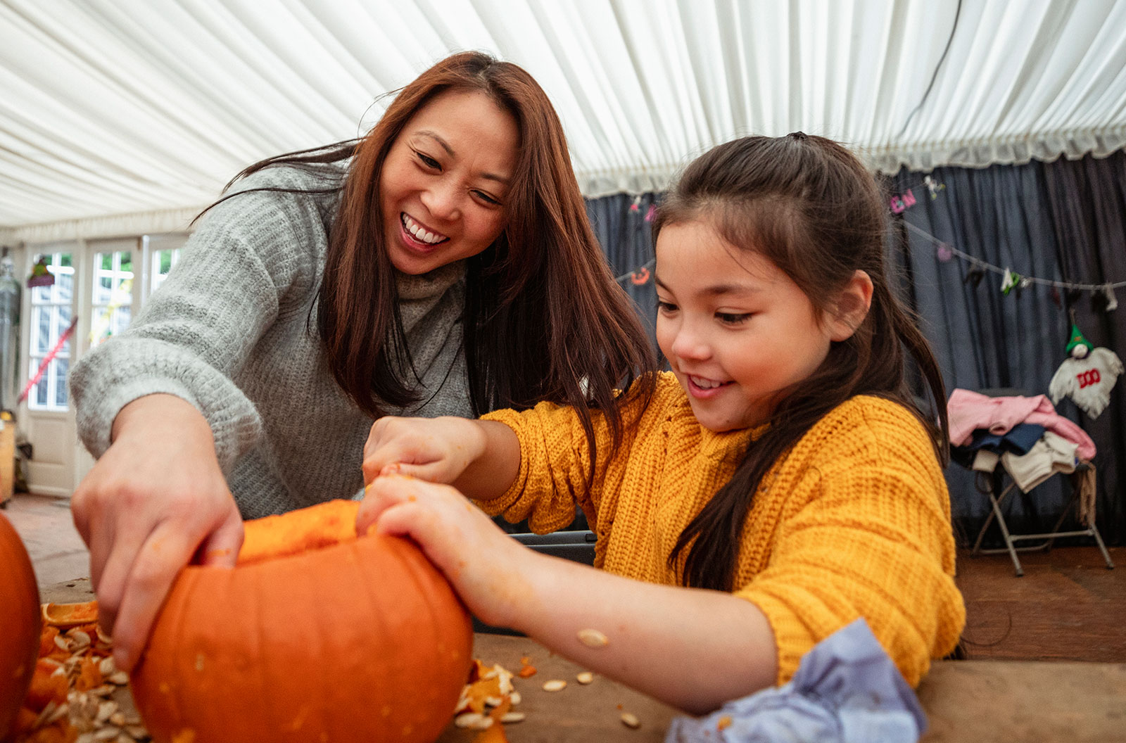 Mother and daughter carving pumpkins