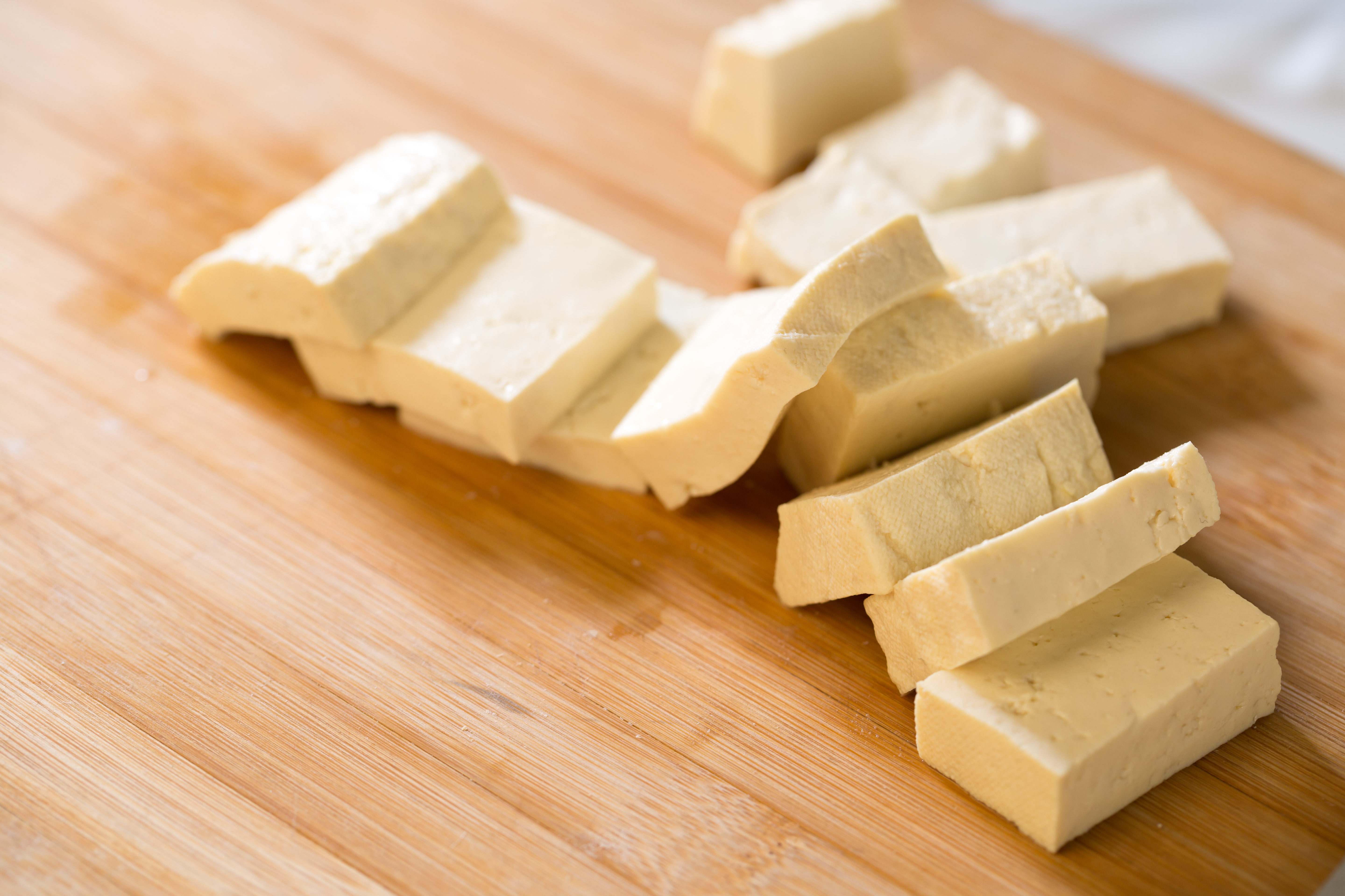 Tofu on wooden table. Preparing food.