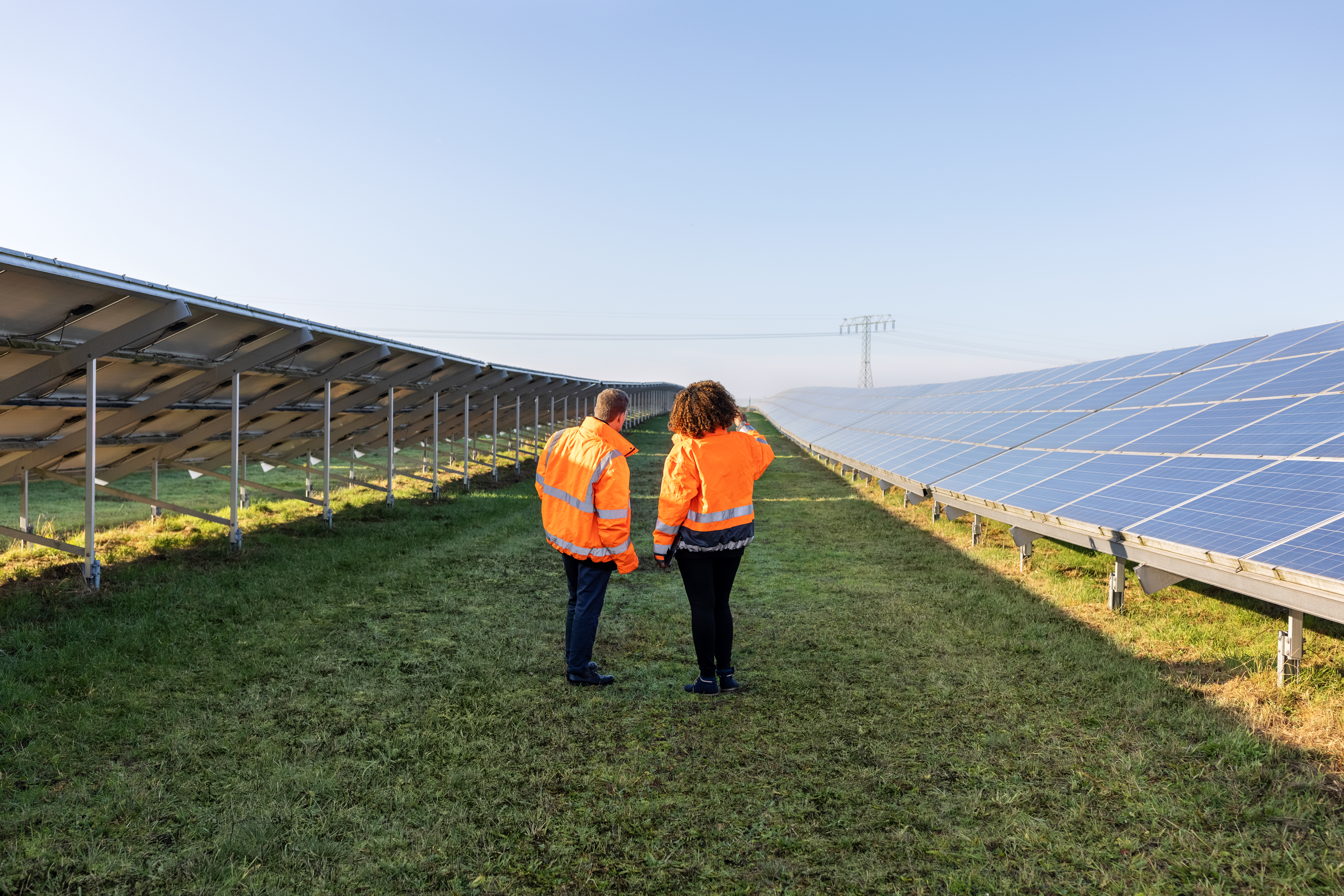 Two field service workers at a solar utilities power array.
