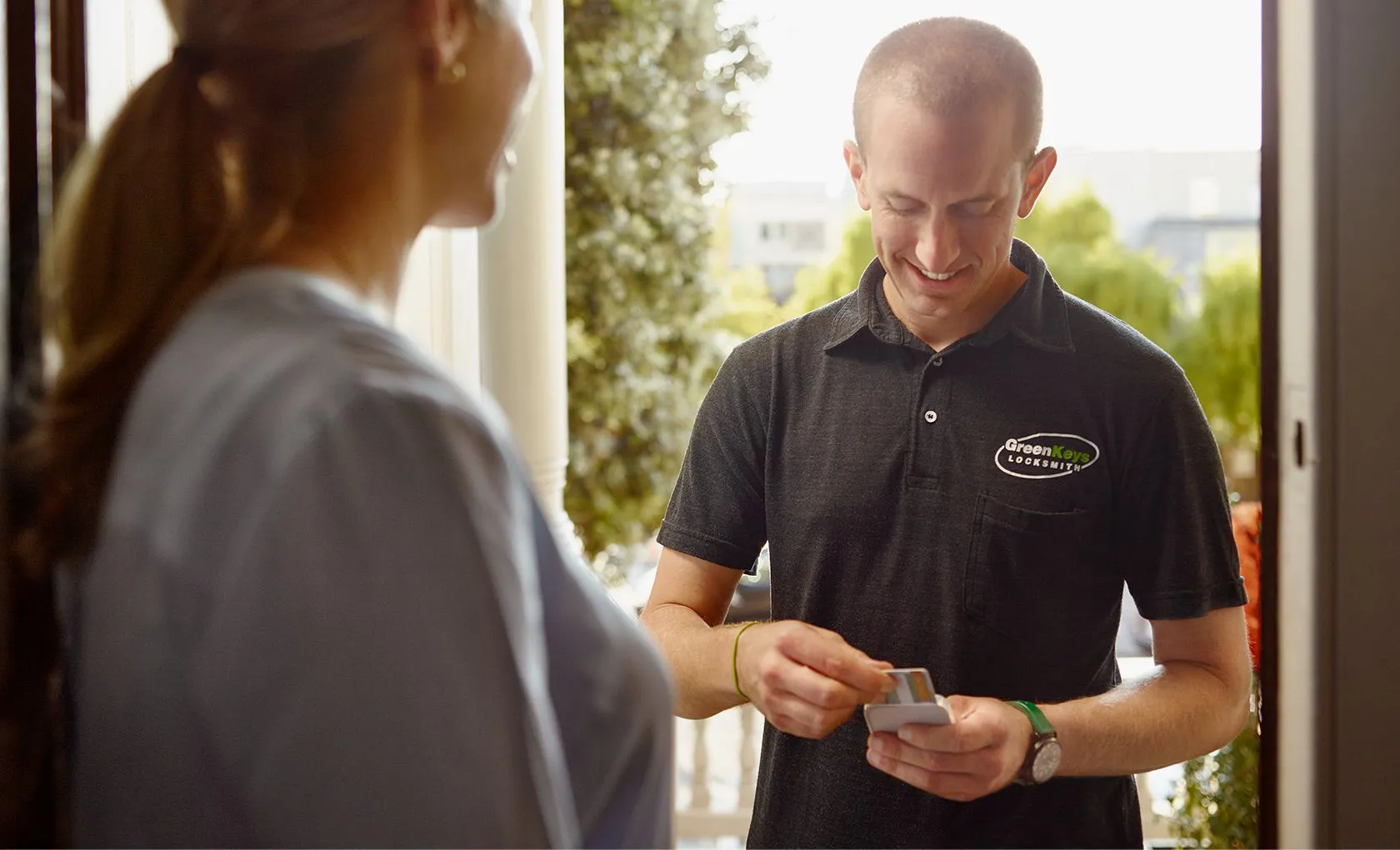 Photo of a locksmith dipping a customer's card into the Square Reader