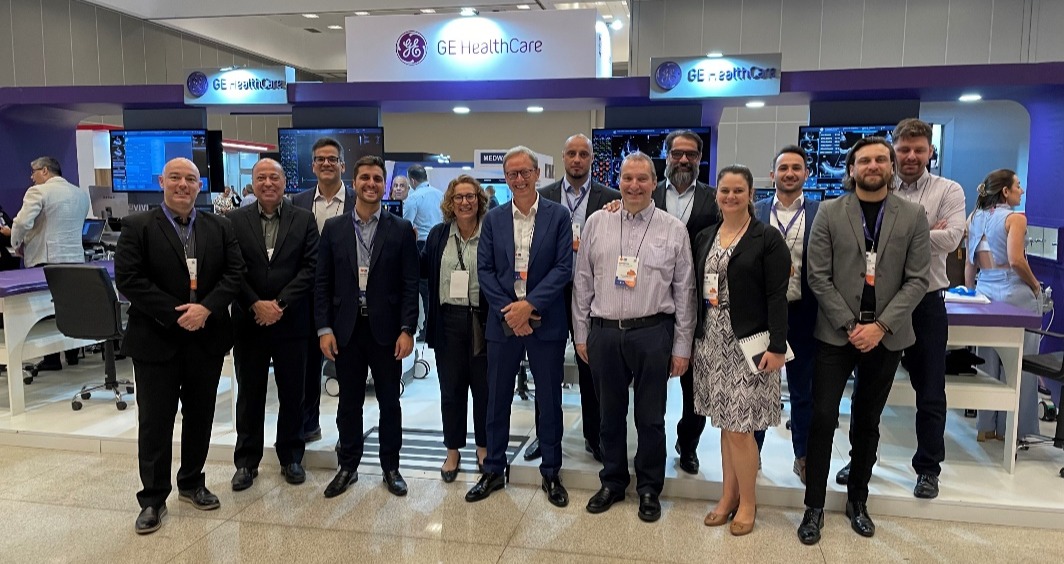 Grupo de pessoas em pé posando para fotoDescrição gerada automaticamente