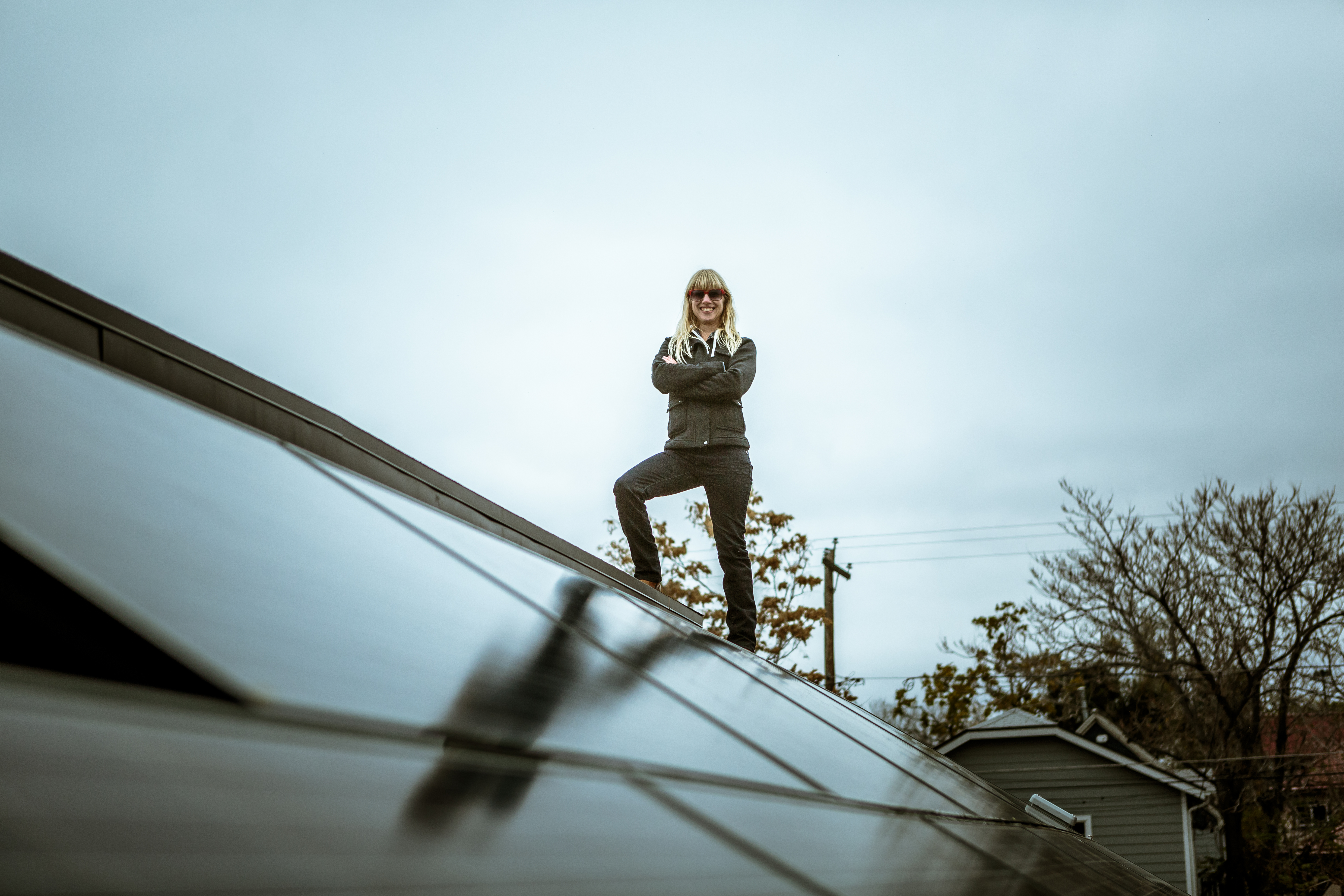 Portrait of mid adult woman standing on newly solar paneled house roof