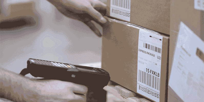 Someone scans a package at a distribution facility