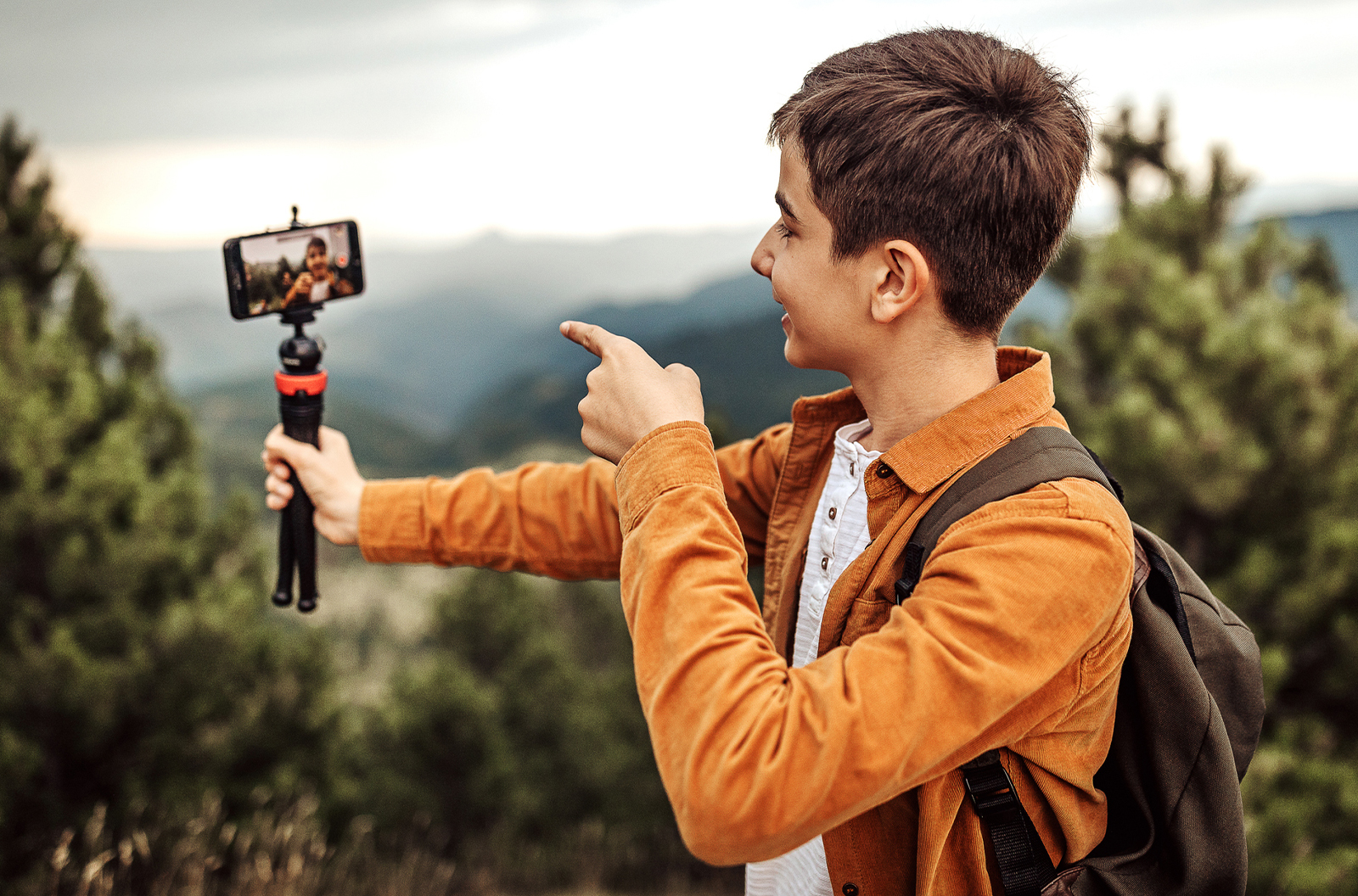 Teenaged boy posing for a selfie in the mountains.