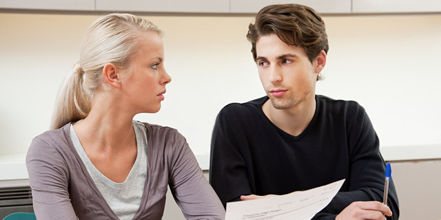 Serious young couple doing home finances
