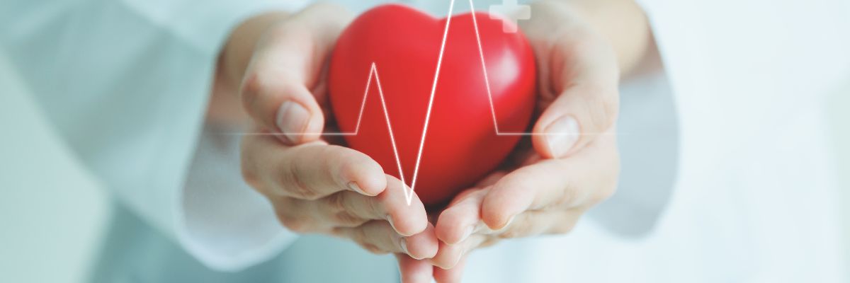 Female medical doctor holding red heart shape in hand with graphic of heart beat, cardiology and insurance concept