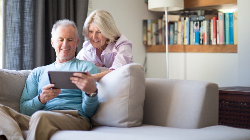 Senior couple using tablet computer at home