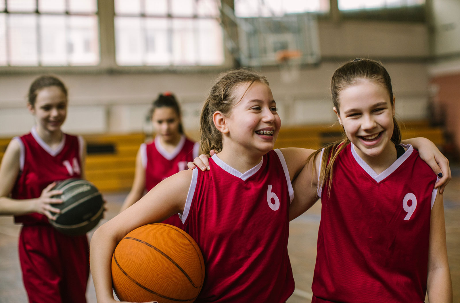 Four girls posing for a photo after a basketball game