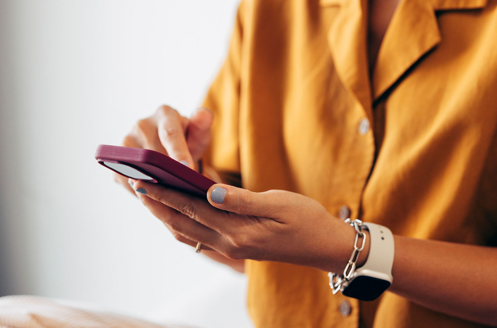 Woman in yellow looking at phone