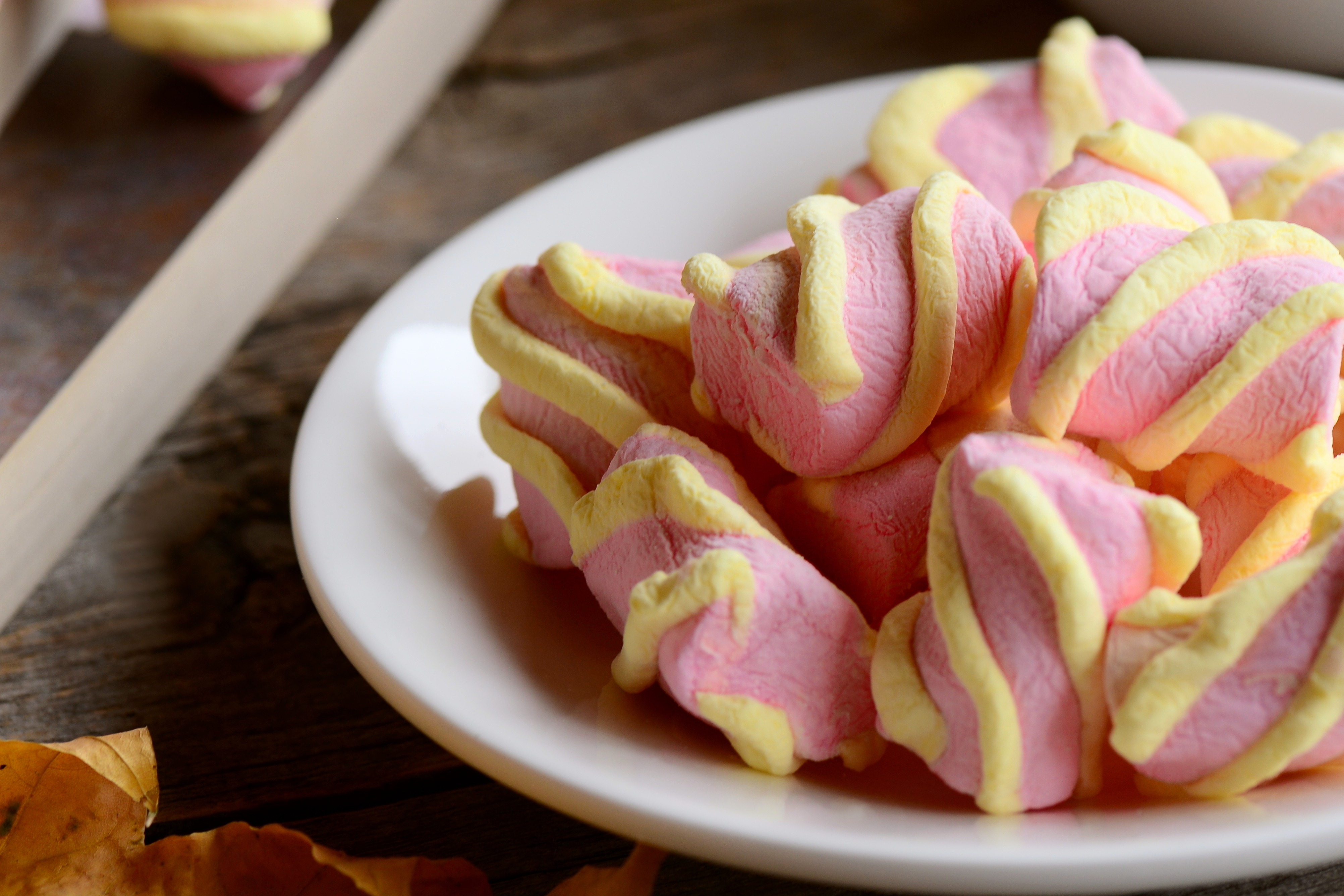 Pastel marshmallow on a plate. Marshmallow candy, sweets on a wooden table. Macro