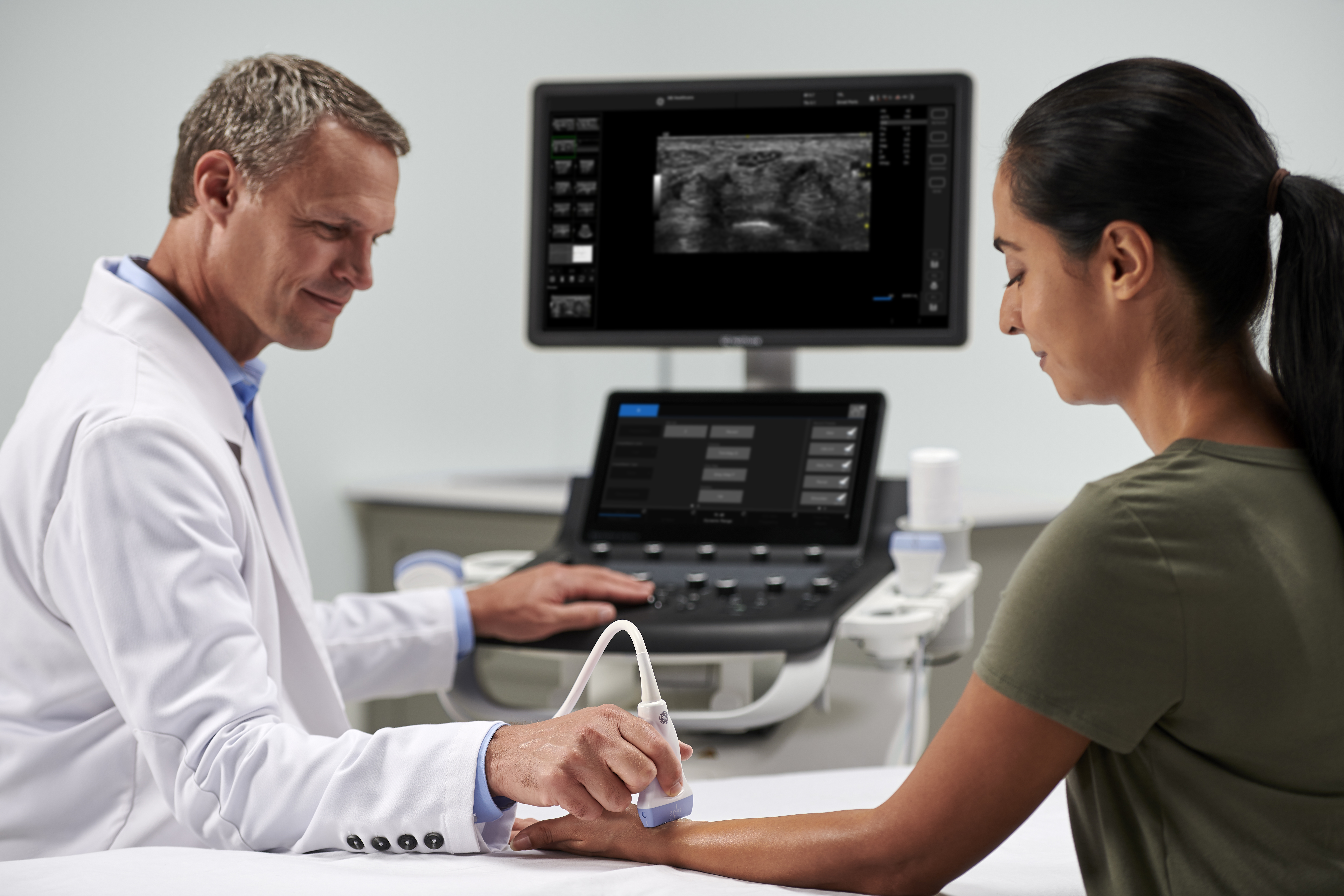 A clinician utilizes ultrasound to scan a patient