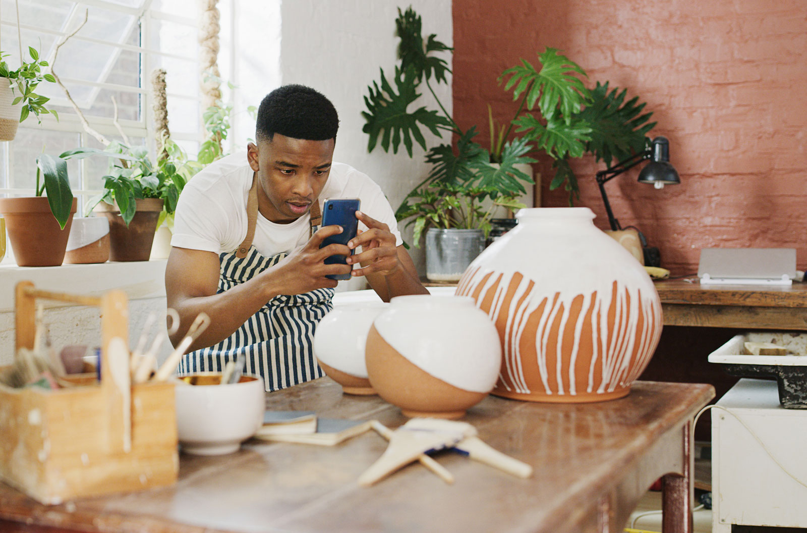 Man taking pictures of his finished products with a smartphone
