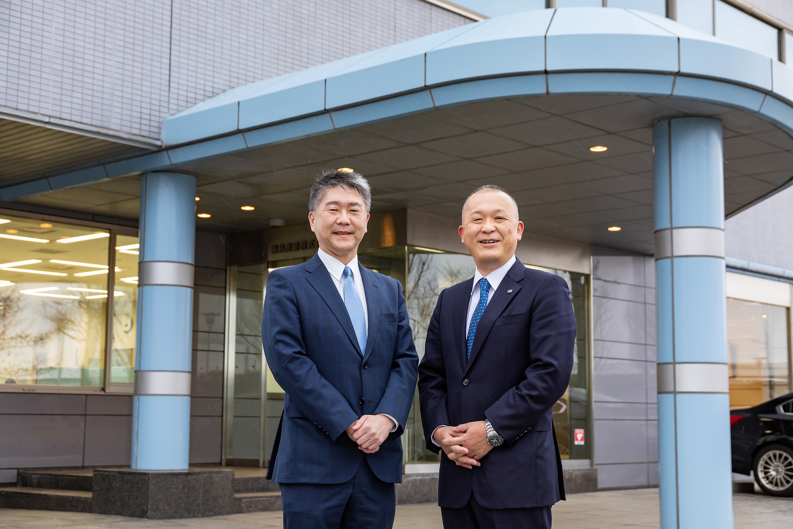 敦井産業株式会社代表取締役・敦井社長様（左）と、敦井産業株式会社前にて。