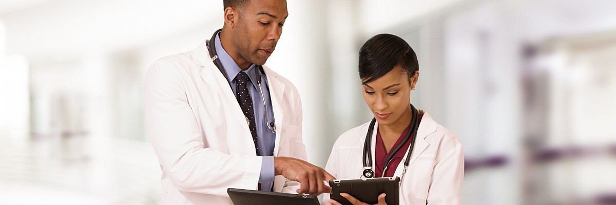Two doctors use tablets to interpret ECG.