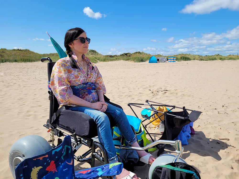 Emma using her beach wheelchair conversion kit on West Sands beach, St Andrews