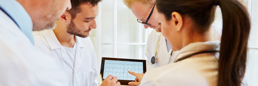 A team of cardiologists in a hospital reviews an ECG for underlying atrial fibrillation