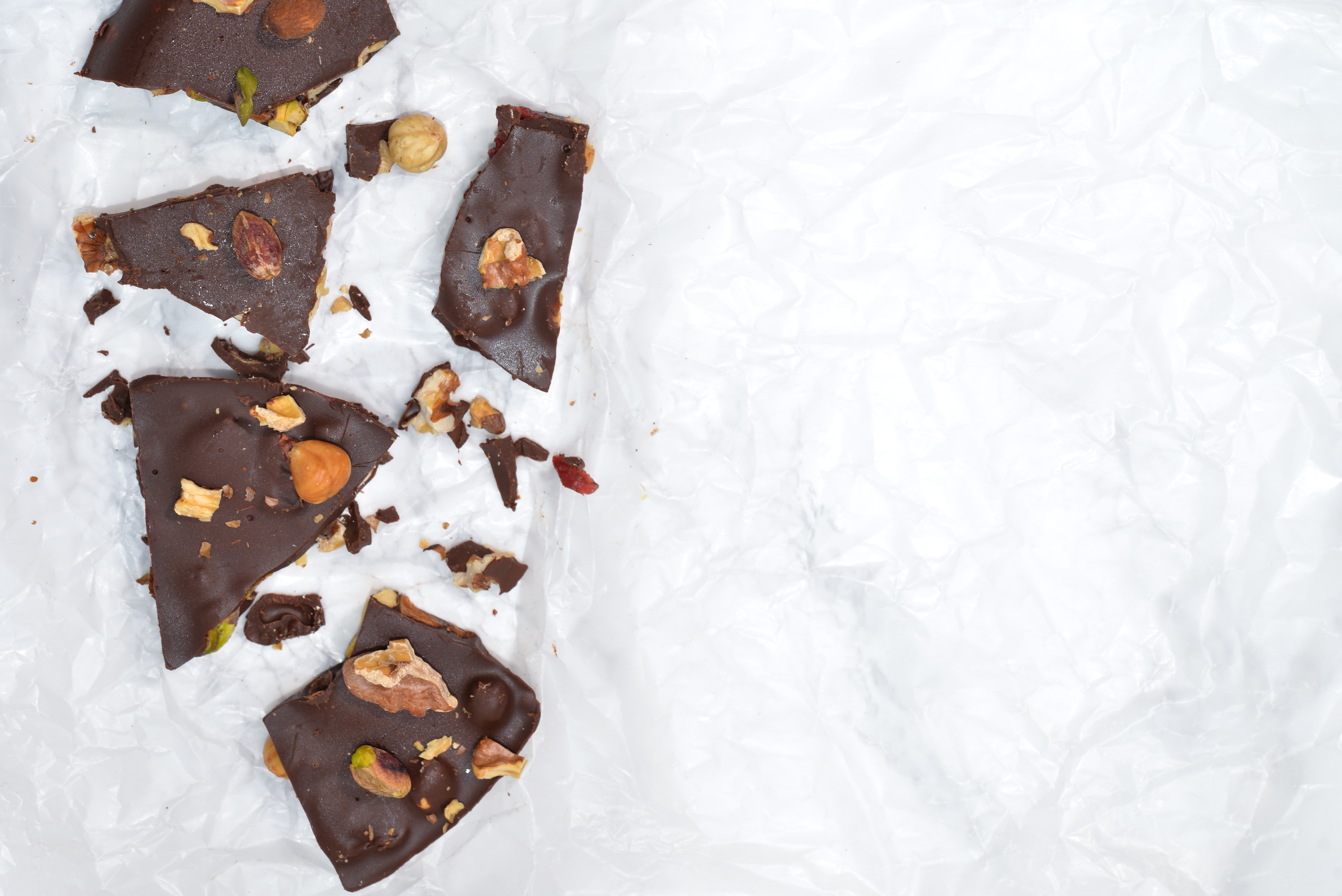 Dark chocolate bark with mixed nuts on wax paper